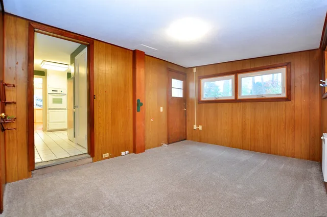 a view of a hallway with wooden floor and a bathroom
