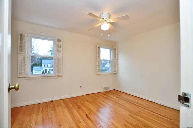 a view of an empty room with wooden floor
