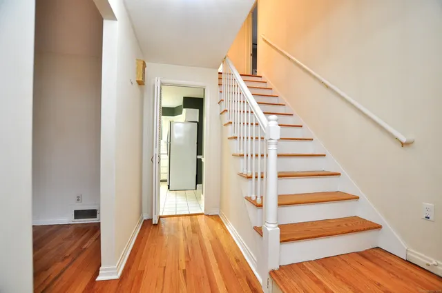 a view of front door with wooden floor and stairs