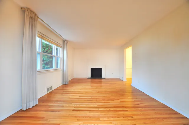 a view of a bedroom with wooden floor and cabinet