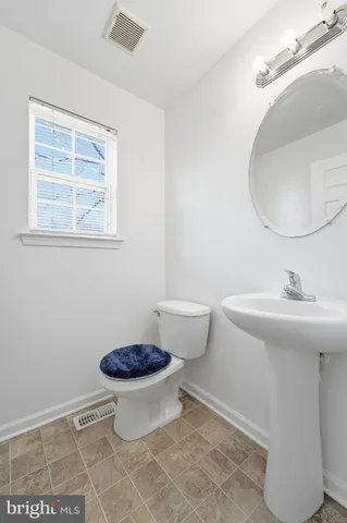 a bathroom with a toilet a sink and a mirror