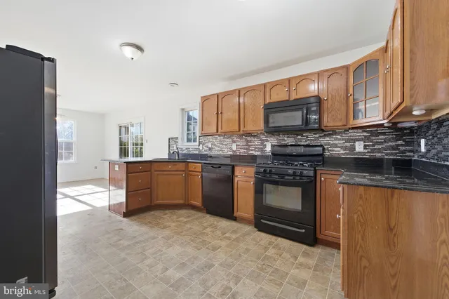 a kitchen with stainless steel appliances granite countertop a stove a sink dishwasher and a refrigerator
