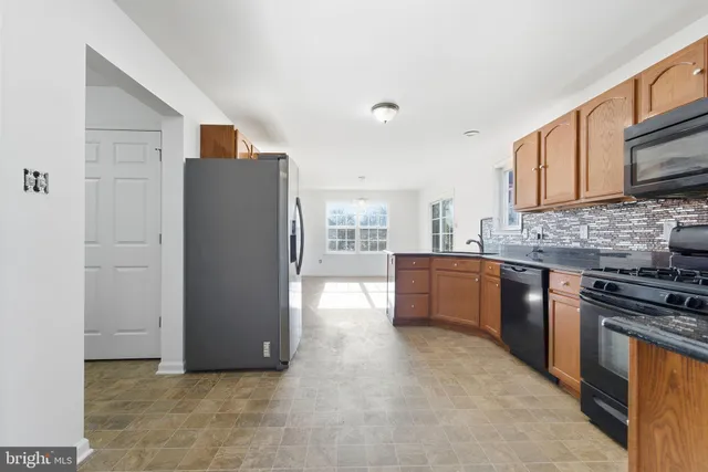 a kitchen with stainless steel appliances a refrigerator a sink a stove top oven and cabinets