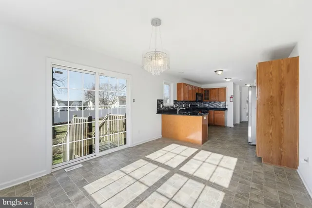 a view of kitchen with granite countertop cabinets and refrigerator