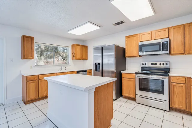 a kitchen with stainless steel appliances granite countertop a stove a sink dishwasher and a refrigerator