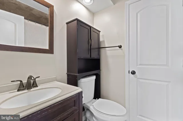 a bathroom with a sink toilet and mirror