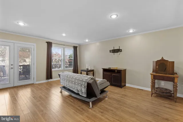a living room with a bed furniture and a flat screen tv