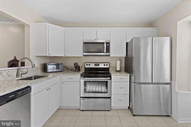 a kitchen with cabinets stainless steel appliances and a counter space