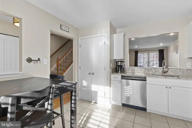 a kitchen with a sink and chairs