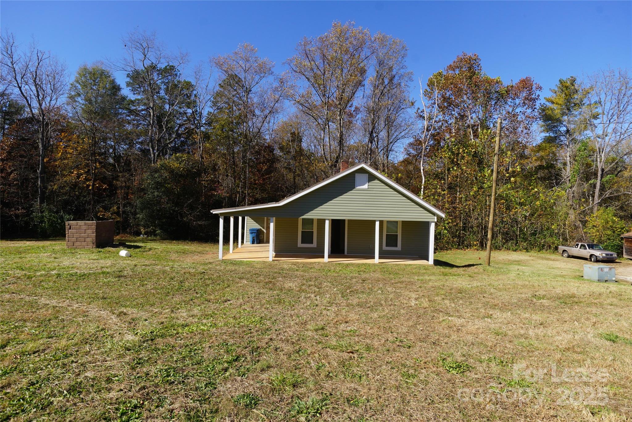a front view of a house with a yard and trees