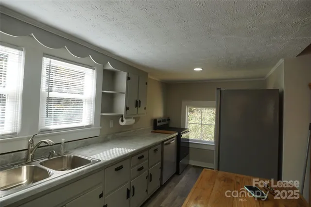 a kitchen with granite countertop a sink stove and cabinets