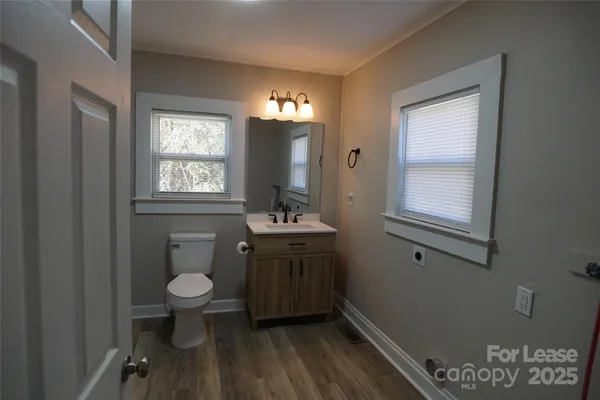 a bathroom with a sink toilet a mirror and window