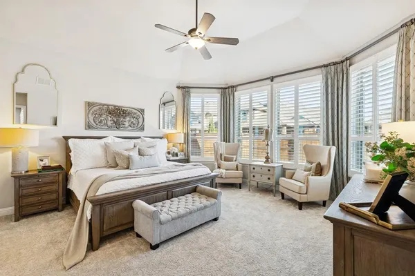 a spacious bedroom with a bed a couch and a large window