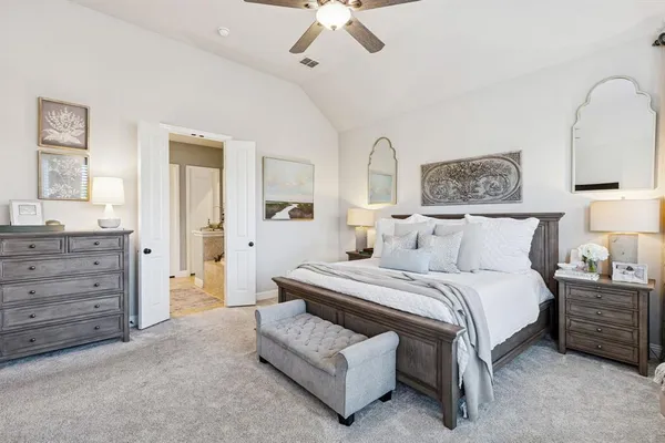 a spacious bedroom with a bed and a chandelier