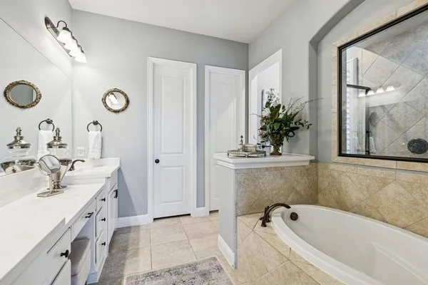 a bathroom with a tub sink and mirror
