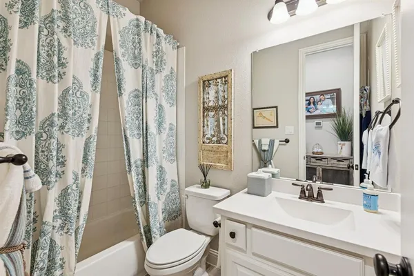 a bathroom with a sink a toilet a mirror and shower