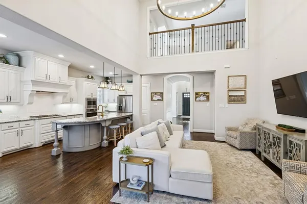 a living room with furniture a flat screen tv and kitchen view