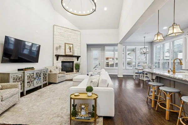 a living room with furniture a flat screen tv and kitchen view