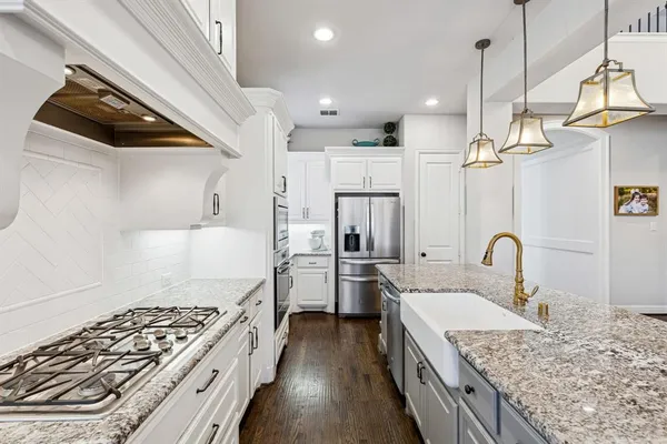 a kitchen with stainless steel appliances granite countertop a sink stove and refrigerator