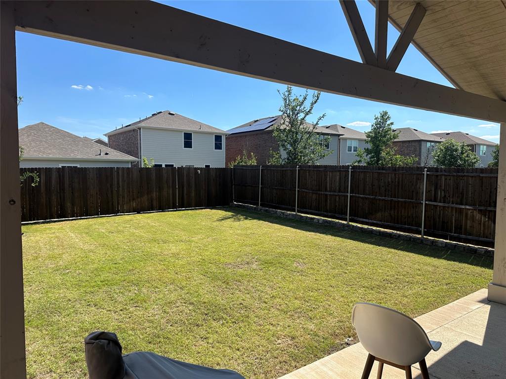 611 Colgate Circle Princeton, TX 75407 - Photo 3 of 9 Expansive backyard featuring a manicured lawn, full privacy fencing, and a concrete patio with an overhead pergola structure
