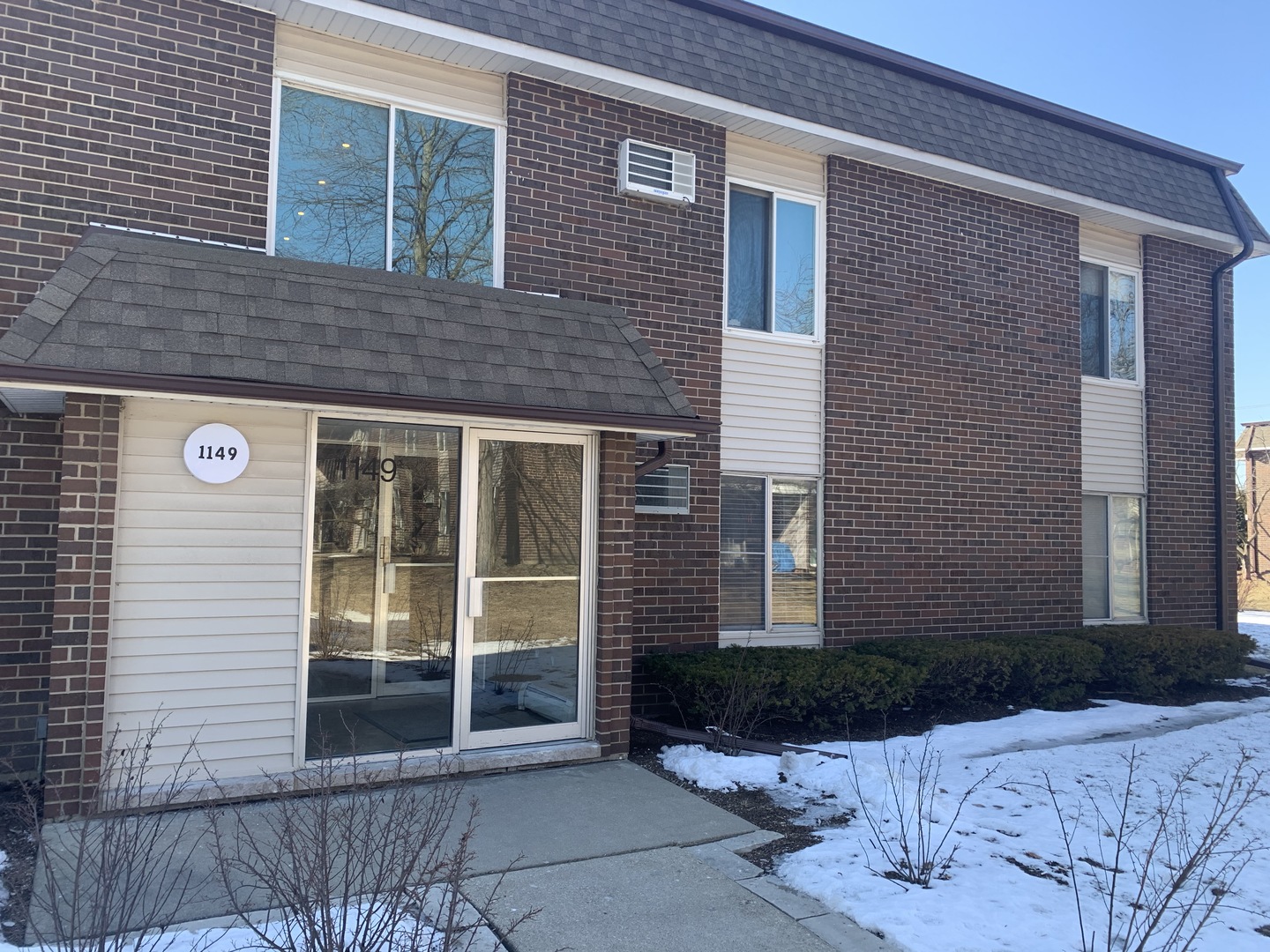 1149 Miller Lane, Unit 212 Buffalo Grove, IL 60089 - Photo 1 of 9 a view of a brick house with a yard