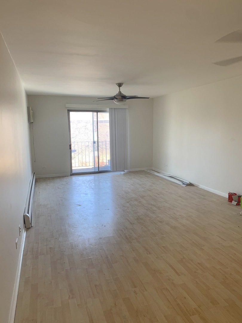 1149 Miller Lane, Unit 212 Buffalo Grove, IL 60089 - Photo 2 of 9 an empty room with wooden floor and windows
