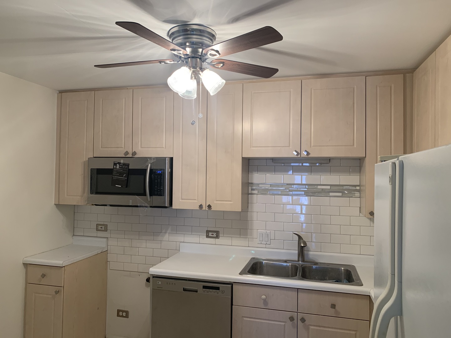 1149 Miller Lane, Unit 212 Buffalo Grove, IL 60089 - Photo 3 of 9 a kitchen with stainless steel appliances a sink a microwave a refrigerator and cabinets