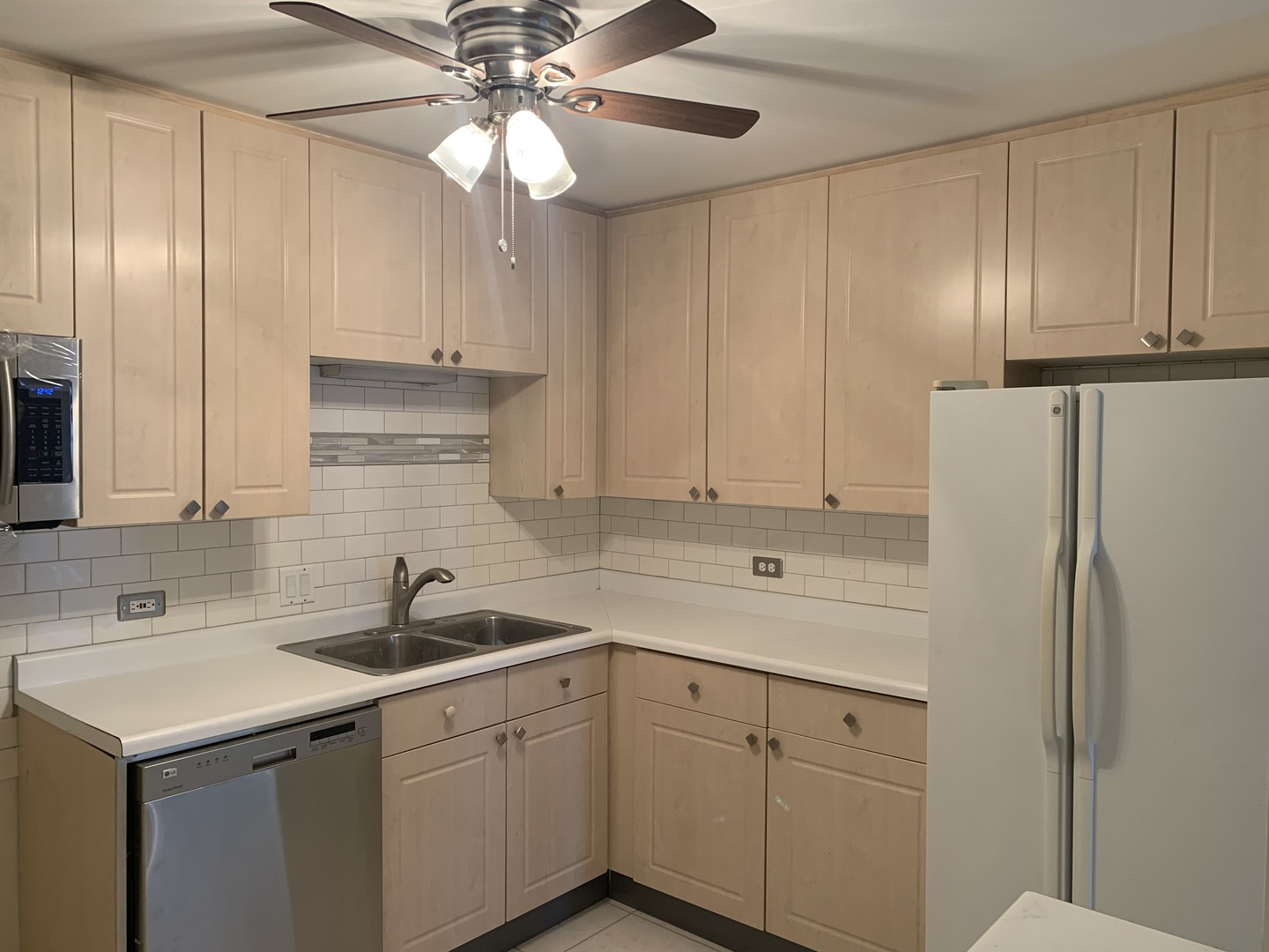 1149 Miller Lane, Unit 212 Buffalo Grove, IL 60089 - Photo 4 of 9 a kitchen with a sink cabinets and stainless steel appliances