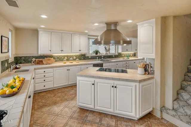 a kitchen with white cabinets and sink