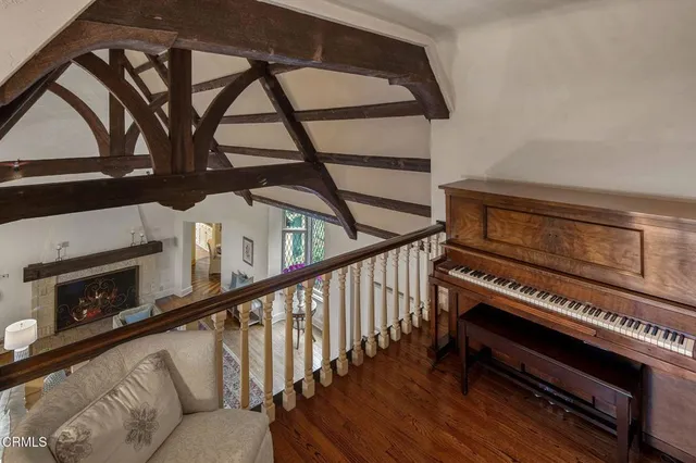 a view of an empty room with wooden floor and stairs