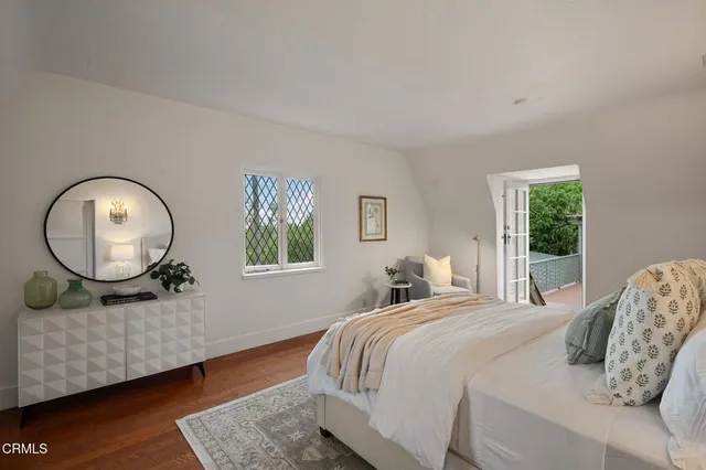 a bedroom with a bed a mirror and a large window