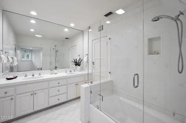 a bathroom with a double vanity sink mirror double and shower