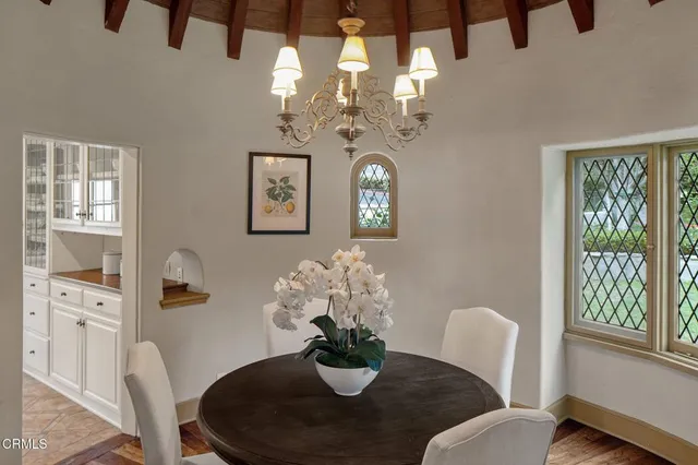 a dining room with furniture a chandelier and window