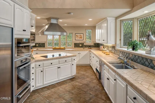 a large kitchen with a large window and stainless steel appliances