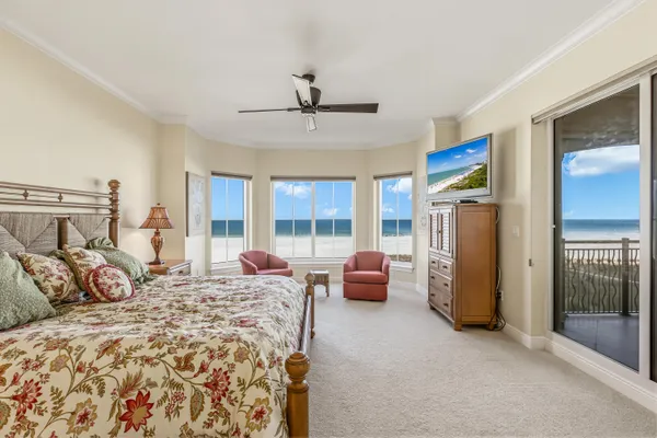 a bedroom with furniture and large windows