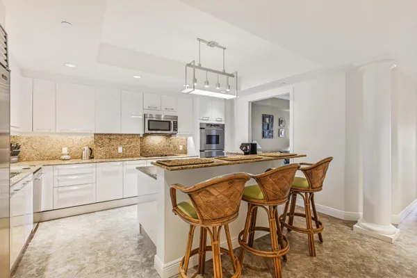 a kitchen with stainless steel appliances granite countertop a sink and a refrigerator