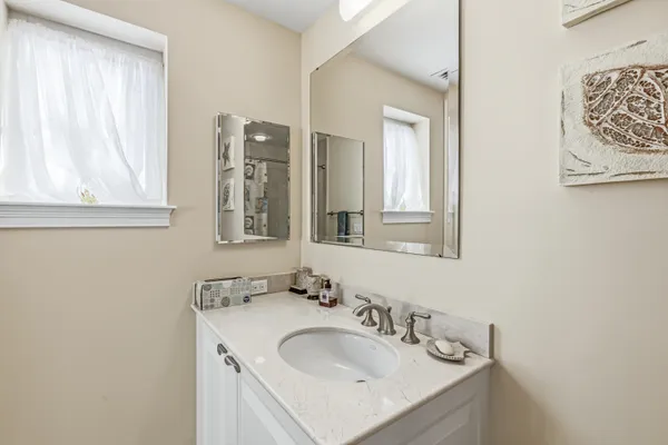 a bathroom with a granite countertop sink and a mirror