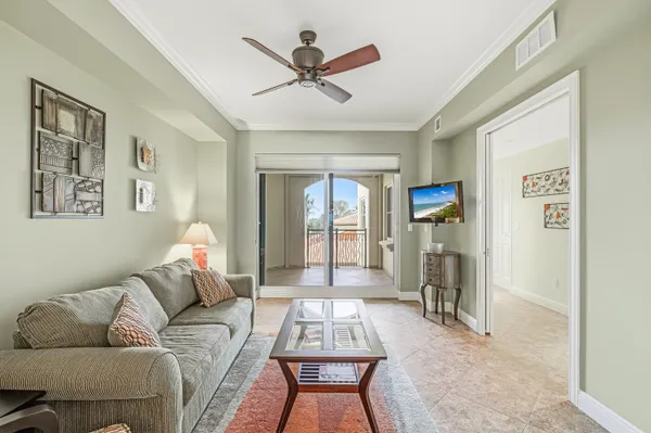 a living room with furniture a ceiling fan and a window