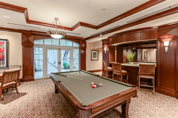 a room with pool table and windows