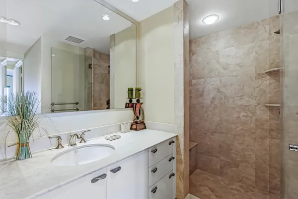 a bathroom with a double vanity sink mirror and shower