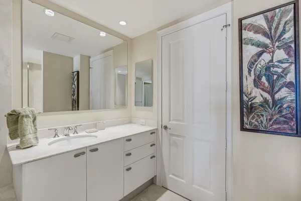 a bathroom with a granite countertop sink a mirror a vanity and a shower