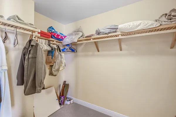 a view of walk in closet with clothes and shoes
