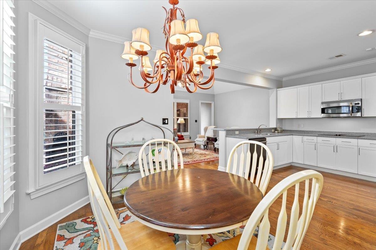 1495 Kimbrough Road Germantown, TN 38138 - Photo 11 of 31 Dining space featuring an inviting chandelier, ornamental molding, and light wood-type flooring