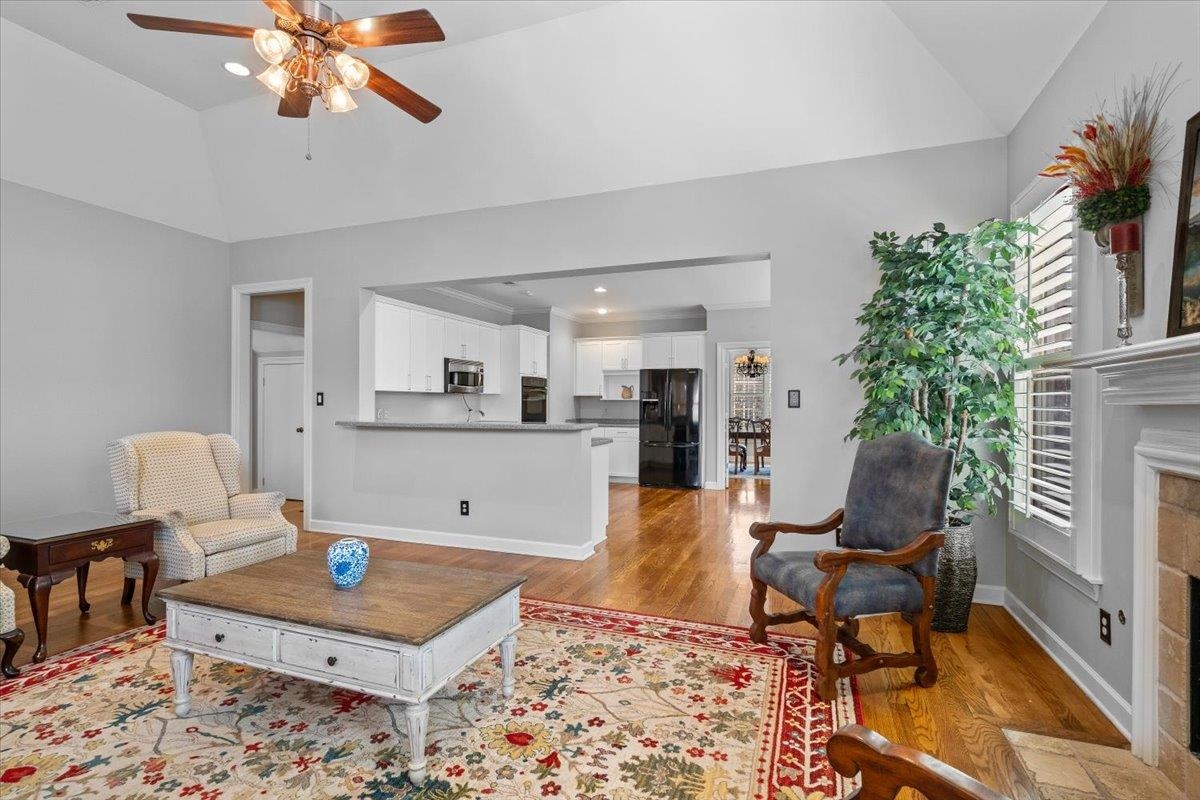 1495 Kimbrough Road Germantown, TN 38138 - Photo 16 of 31 Living area with a fireplace, ceiling fan, light wood-type flooring, and vaulted ceiling