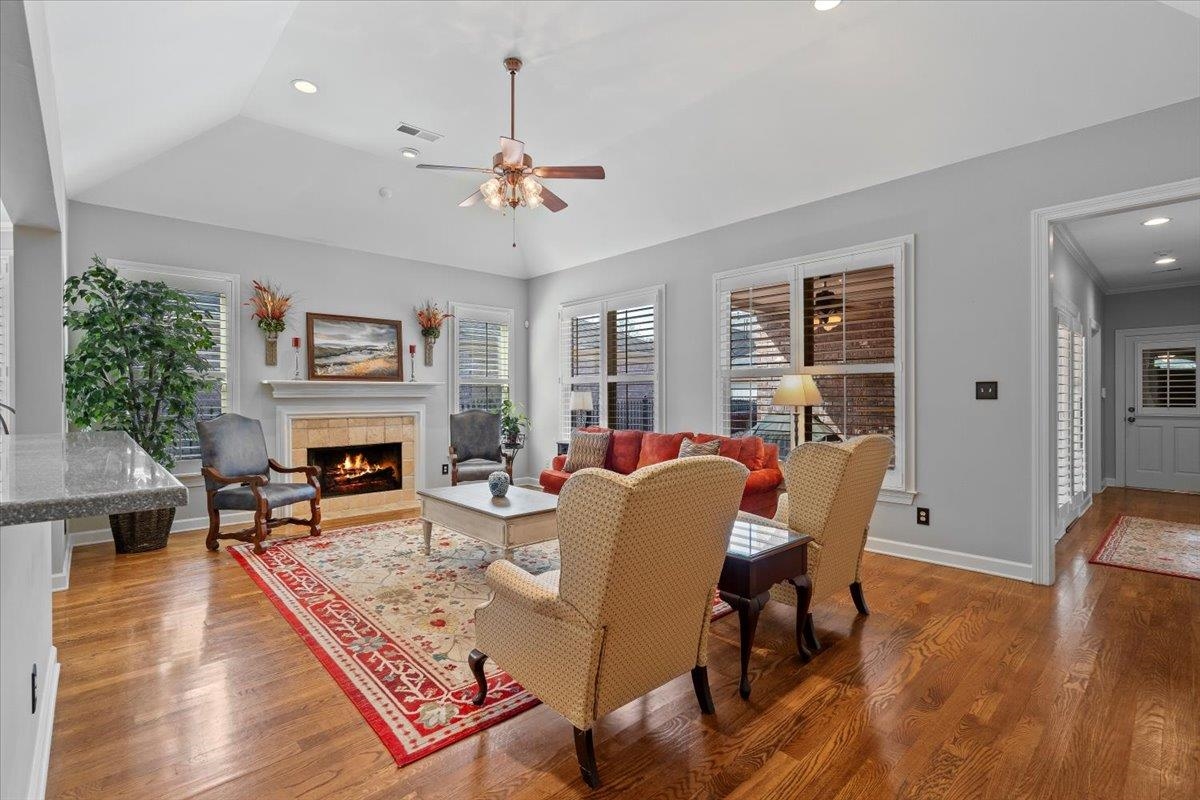 1495 Kimbrough Road Germantown, TN 38138 - Photo 17 of 31 Living area featuring visible vents, a tiled fireplace, a ceiling fan, and wood finished floors