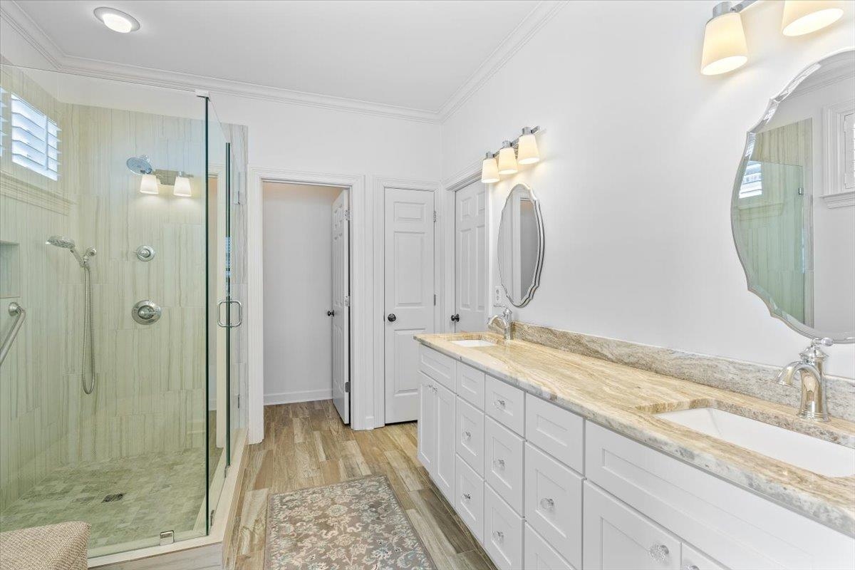 1495 Kimbrough Road Germantown, TN 38138 - Photo 19 of 31 Full bath featuring a sink, a shower stall, wood finished floors, ornamental molding, and double vanity