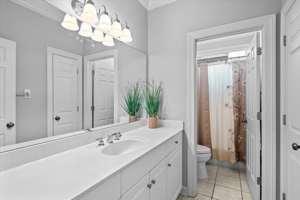1495 Kimbrough Road Germantown, TN 38138 - Photo 22 of 31 Full bath featuring a chandelier, ornamental molding, toilet, vanity, and tile patterned flooring