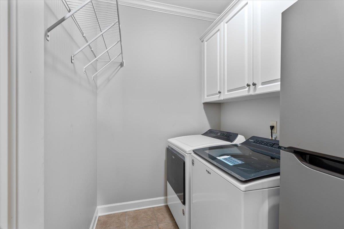 1495 Kimbrough Road Germantown, TN 38138 - Photo 24 of 31 Laundry area with crown molding, independent washer and dryer, light tile patterned floors, baseboards, and cabinet space