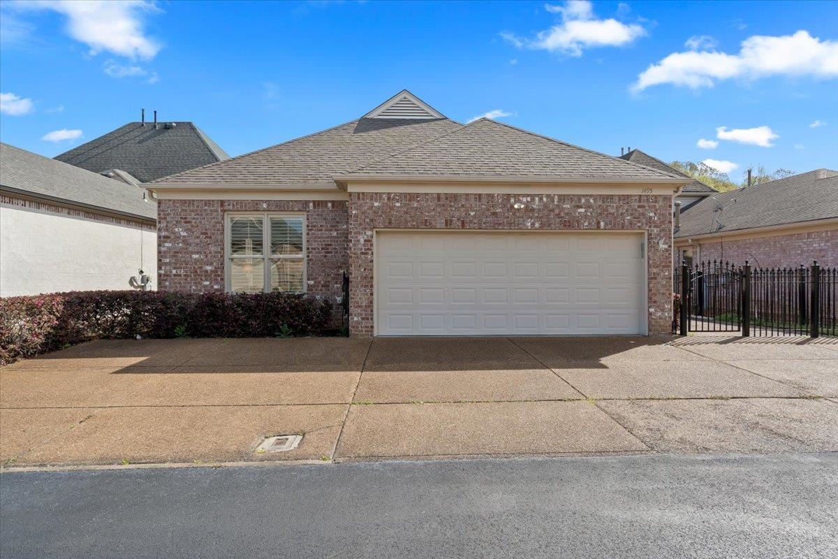 1495 Kimbrough Road Germantown, TN 38138 - Photo 28 of 31 View of front of house with fence, an attached garage, driveway, brick siding, and a shingled roof