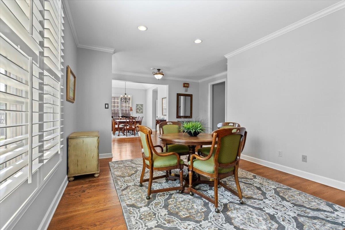 1495 Kimbrough Road Germantown, TN 38138 - Photo 7 of 31 Dining area with baseboards, ornamental molding, wood finished floors, and an inviting chandelier